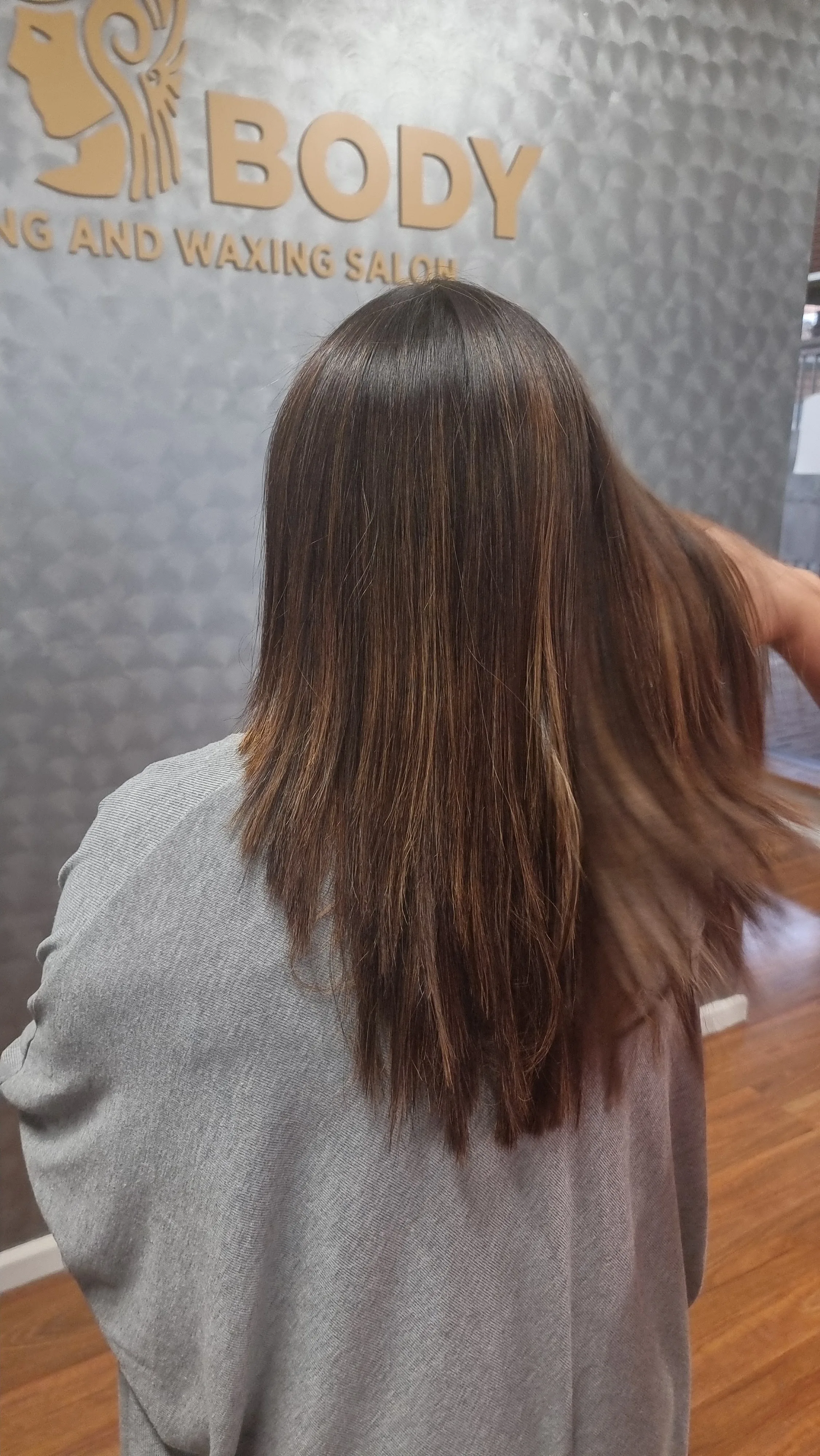 Smooth blow-dry result against the gold Silk Body logo wall