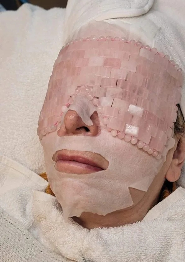 Relaxing facial treatment with rose-quartz eye mask
