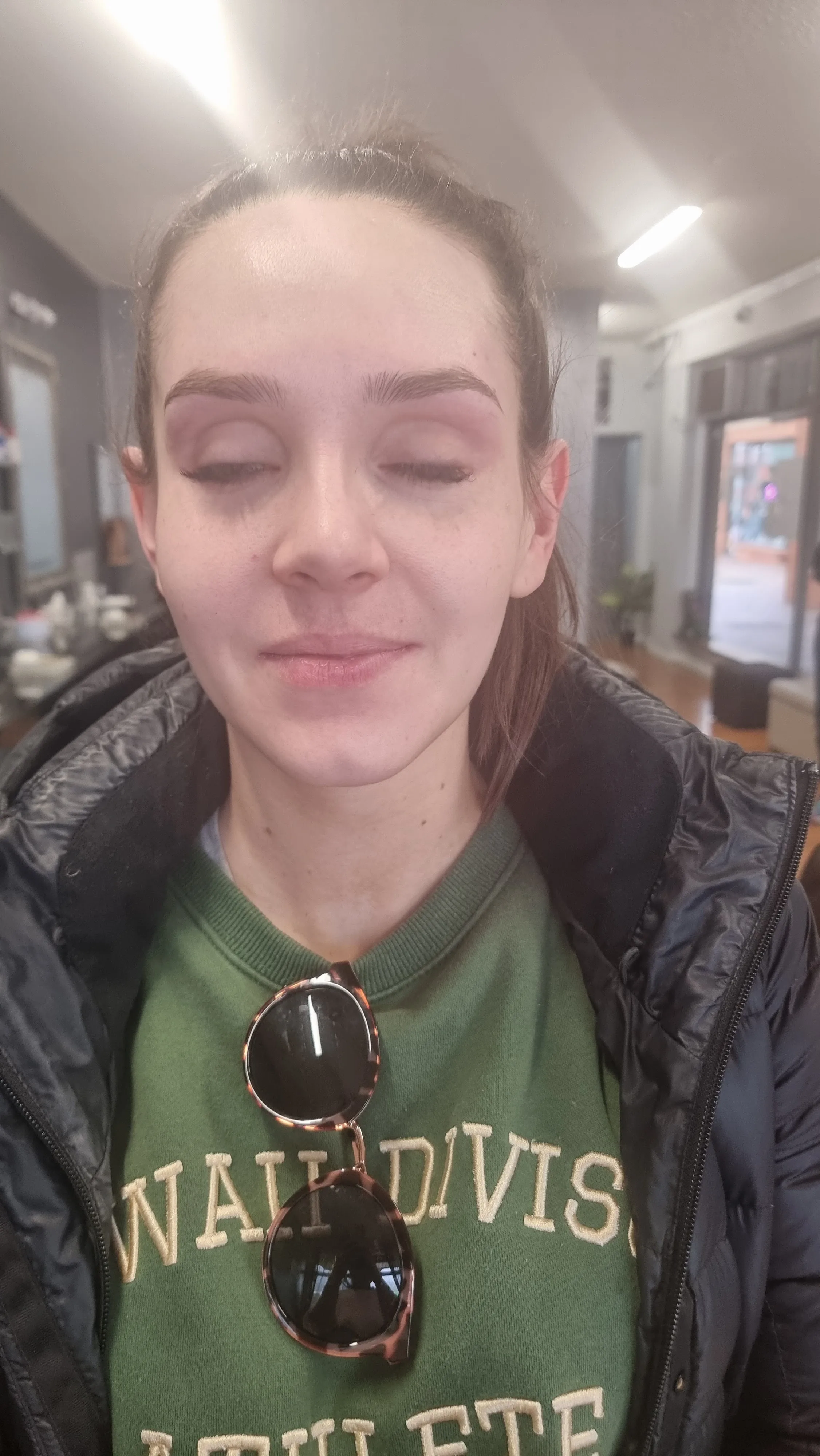 Brow threading result with the salon floor visible behind